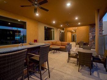 a covered patio with a bar and couches